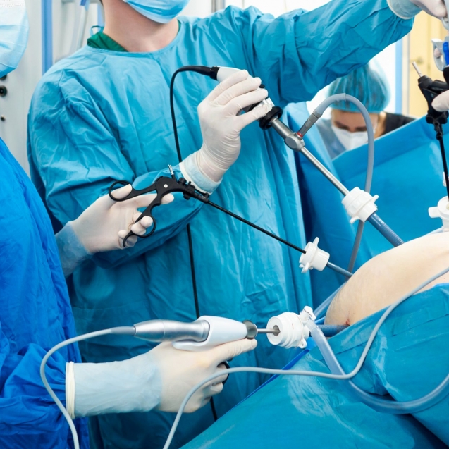 Surgeons wearing latex gloves and blue uniforms perform laparoscopic minimally invasive surgery using special medical instruments. Treatment of proctological diseases.
